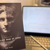 Customer-uploaded image. Click to see more details. The image represents: Book cover titled "The Black Book of Power Limited Edition" by Stan Taylor displayed next to a laptop computer on a desk