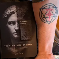 Customer-uploaded image. Click to see more details. The image represents: A book titled "The Black Book of Power" by Stan Taylor next to a person's arm showing a circular tattoo with geometric patterns in black and red ink.