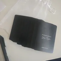 Customer-uploaded image. Click to see more details. The image represents: A stack of black business cards or promotional materials with "Stan Taylor" signature and website "STANTAYLOR.COM" visible on the top card, placed on a white surface next to what appears to be a laptop or electronic device.