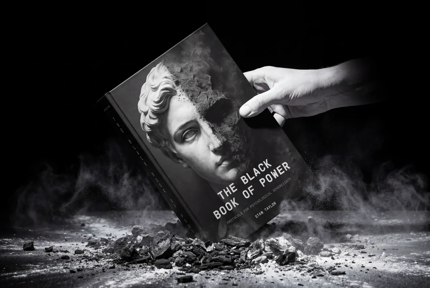 The Black Book of Power by Stan Taylor, marble-face cover rising from ash as a finger touches it